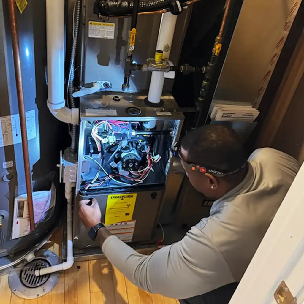 A home inspector checking the internal mechanical components of a furnace.